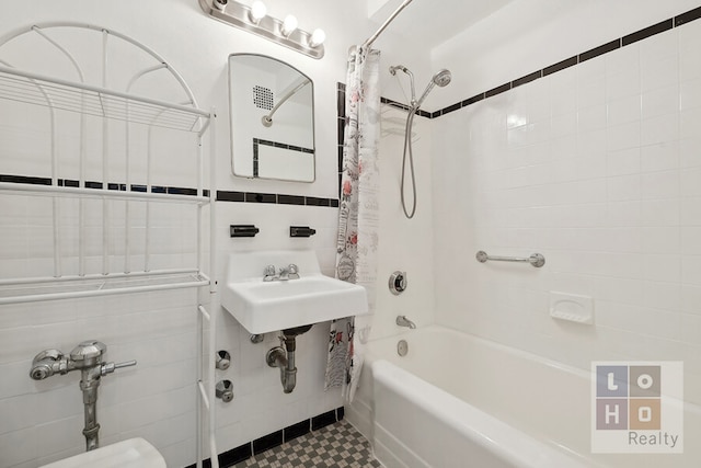 bathroom with shower / bath combination with curtain and tile walls