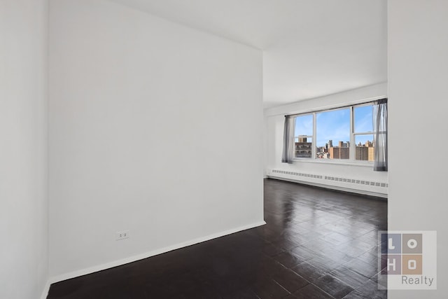 unfurnished room featuring radiator heating unit, baseboards, and dark wood-style flooring