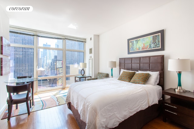 bedroom with wood-type flooring and expansive windows