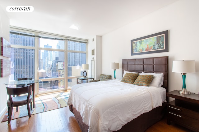 bedroom featuring hardwood / wood-style flooring, visible vents, and floor to ceiling windows