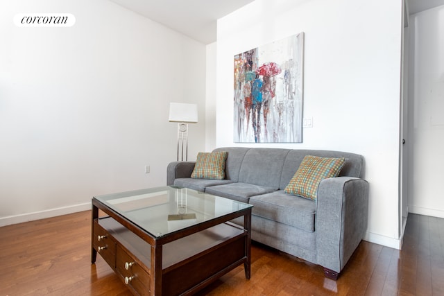 living room with visible vents, baseboards, and hardwood / wood-style flooring