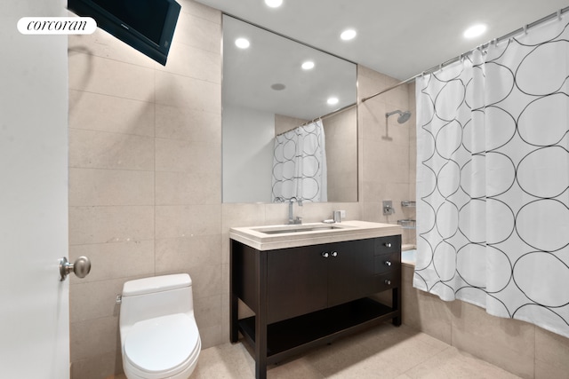 bathroom with tiled shower / bath, tile walls, recessed lighting, toilet, and vanity