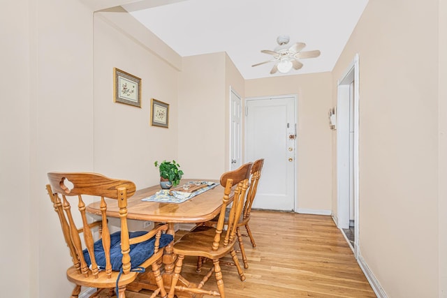 dining room featuring baseboards, ceiling fan, and light wood-style floors