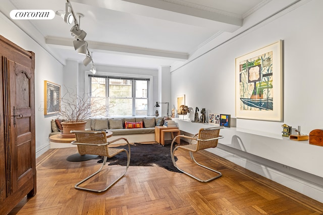 living area featuring baseboards, visible vents, and beam ceiling