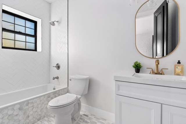 full bathroom featuring tiled shower / bath, vanity, and toilet