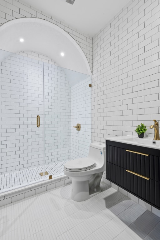 bathroom with tile walls, tile patterned floors, toilet, and walk in shower