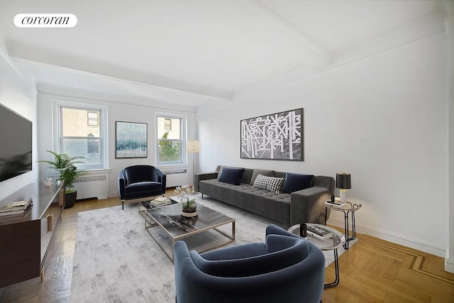 living area featuring baseboards, radiator heating unit, visible vents, and beamed ceiling