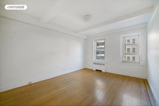250 Cabrini Blvd Unit 5C, New York City, NY 10033 - unfurnished room featuring radiator heating unit, hardwood / wood-style floors, beamed ceiling, and baseboards