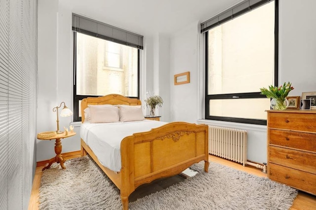 bedroom featuring radiator and wood finished floors