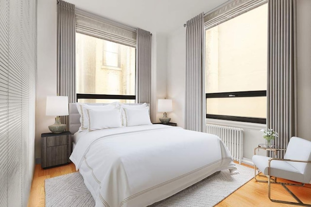 bedroom with wood finished floors and radiator heating unit