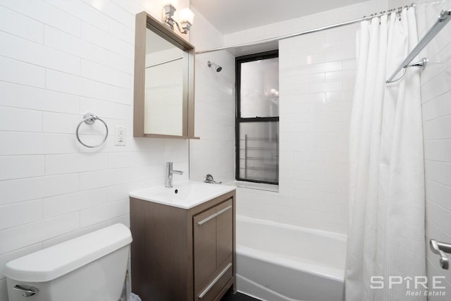 bathroom featuring vanity, toilet, tile walls, and shower / tub combo