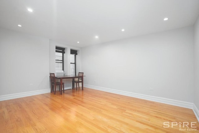 empty room featuring recessed lighting, baseboards, and light wood finished floors