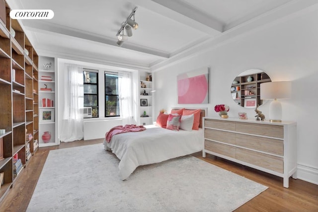 bedroom with hardwood / wood-style flooring, rail lighting, and beam ceiling