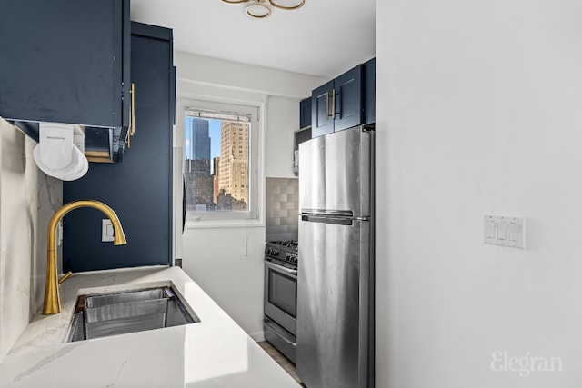 kitchen with blue cabinets, appliances with stainless steel finishes, sink, and decorative backsplash