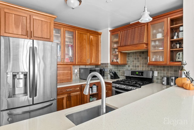 kitchen featuring custom exhaust hood, tasteful backsplash, sink, decorative light fixtures, and stainless steel appliances