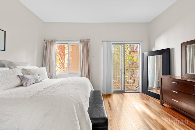 bedroom with multiple windows, access to outside, and light hardwood / wood-style flooring