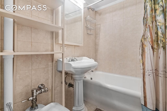 bathroom featuring ornamental molding, shower / bath combo with shower curtain, and tile walls