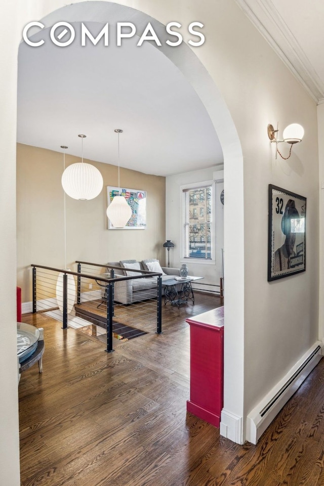 corridor featuring dark wood-style floors, a baseboard radiator, arched walkways, and baseboards