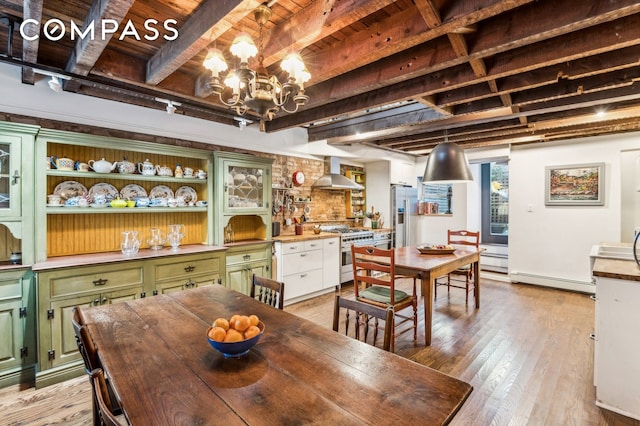 dining area with beamed ceiling, baseboard heating, light wood-type flooring, and a notable chandelier