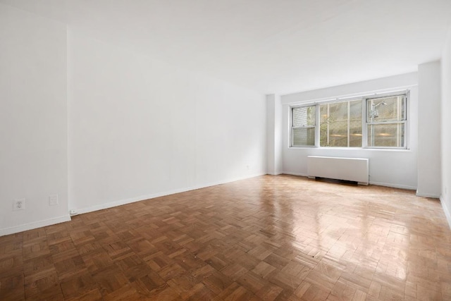 empty room with radiator and parquet floors