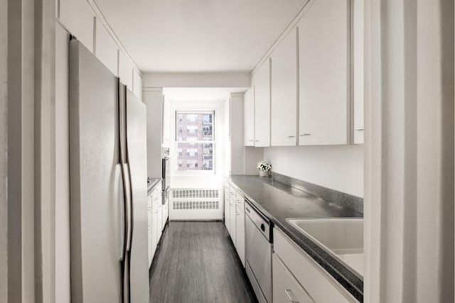 kitchen featuring white cabinetry, stainless steel dishwasher, white refrigerator, and radiator