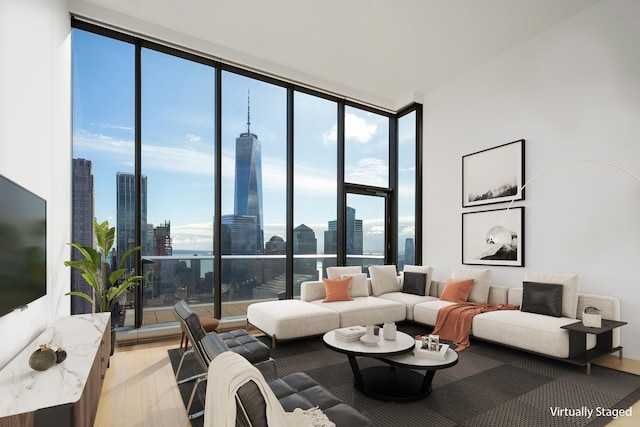 living room with light wood-type flooring, a healthy amount of sunlight, expansive windows, and a city view