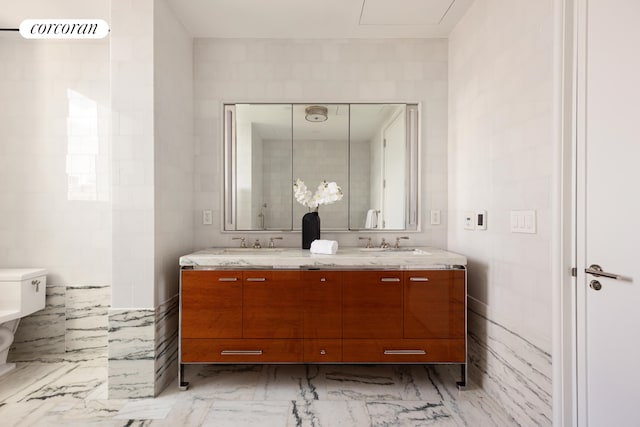 45 E 22nd St Unit 26B, New York City, NY 10010 - bathroom with double vanity, toilet, marble finish floors, and tile walls