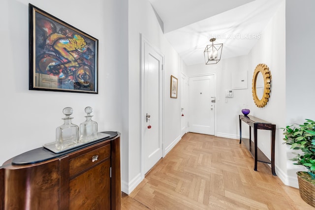 foyer entrance featuring baseboards and a notable chandelier