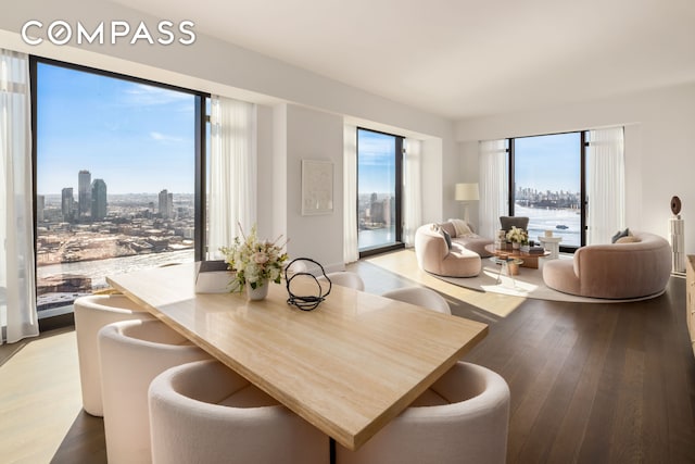 dining space featuring a view of city and wood finished floors