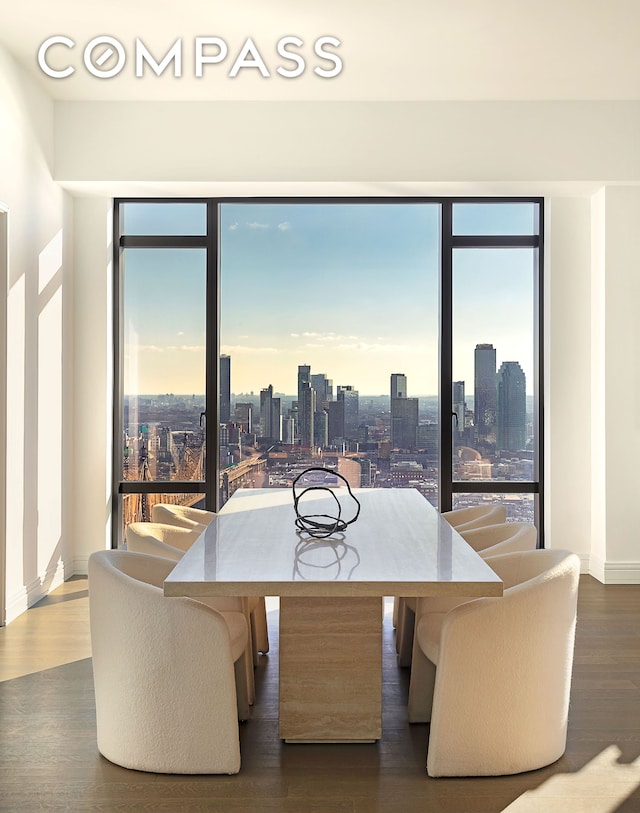 dining space featuring a view of city, baseboards, and wood finished floors