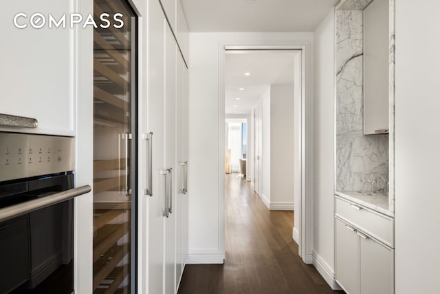 corridor featuring recessed lighting, baseboards, beverage cooler, and dark wood-style flooring