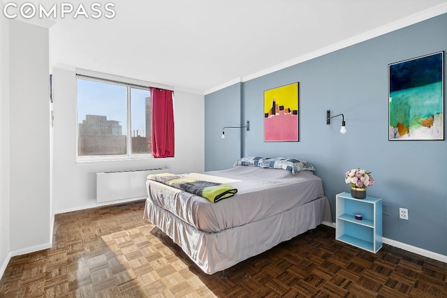 bedroom featuring radiator heating unit, crown molding, and dark parquet floors