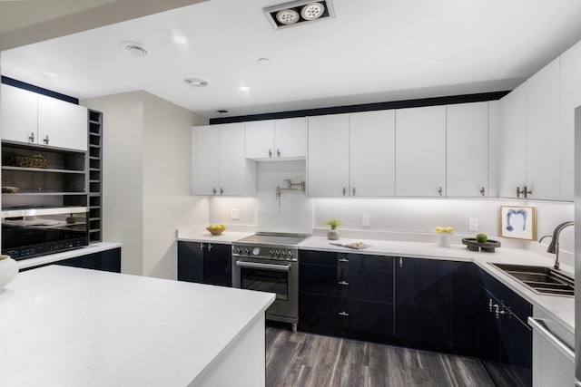 kitchen with dark wood-type flooring, stainless steel appliances, sink, and white cabinets