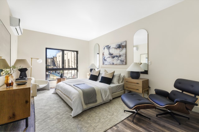 bedroom with wood-type flooring and an AC wall unit