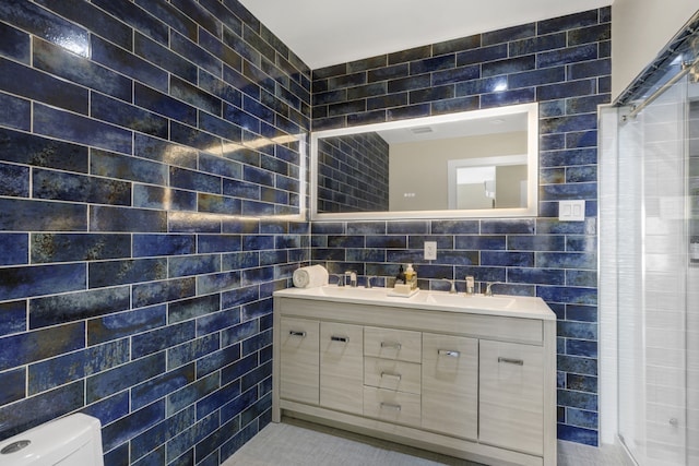 bathroom featuring tile walls, vanity, and toilet