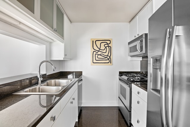 kitchen featuring baseboards, stainless steel appliances, granite finish floor, white cabinetry, and a sink