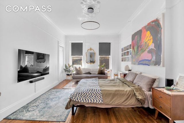 bedroom featuring baseboards, wood finished floors, and ornamental molding