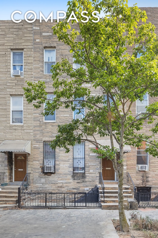 view of front facade featuring a fenced front yard and stone siding