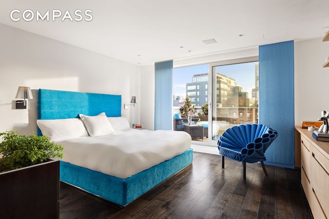 bedroom featuring access to exterior, a view of city, and dark wood finished floors