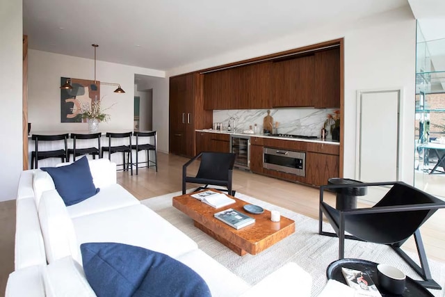 living room with light wood-type flooring and beverage cooler