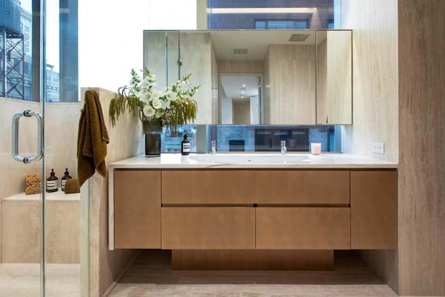 bathroom featuring backsplash, walk in shower, and vanity