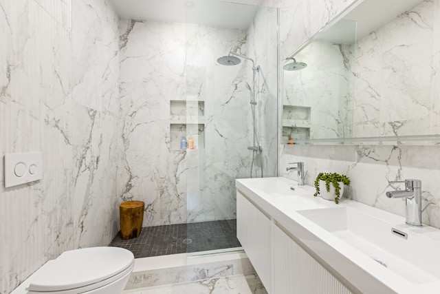 bathroom featuring tiled shower, vanity, toilet, and tile walls