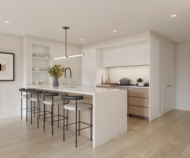 kitchen with a sink, open shelves, a breakfast bar area, and modern cabinets