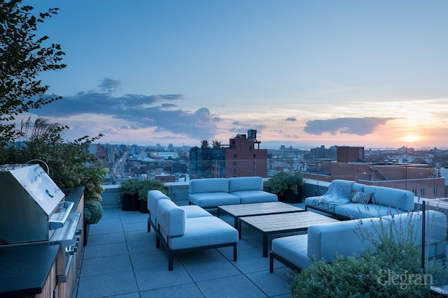 patio terrace at dusk featuring an outdoor hangout area and area for grilling