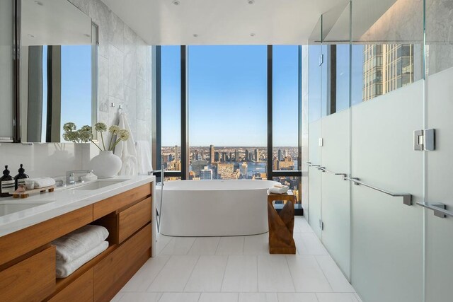 bathroom featuring vanity, separate shower and tub, a wealth of natural light, and tile patterned floors