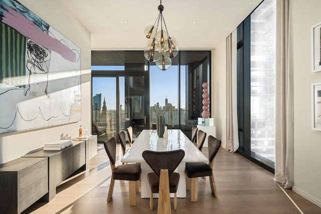 dining space featuring hardwood / wood-style flooring, floor to ceiling windows, and a notable chandelier