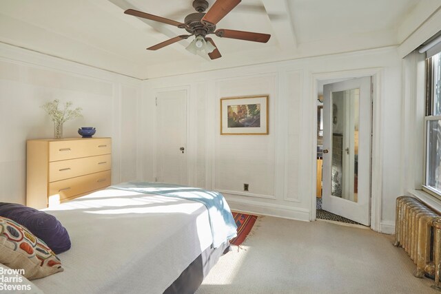 carpeted bedroom featuring ceiling fan, beamed ceiling, and radiator heating unit