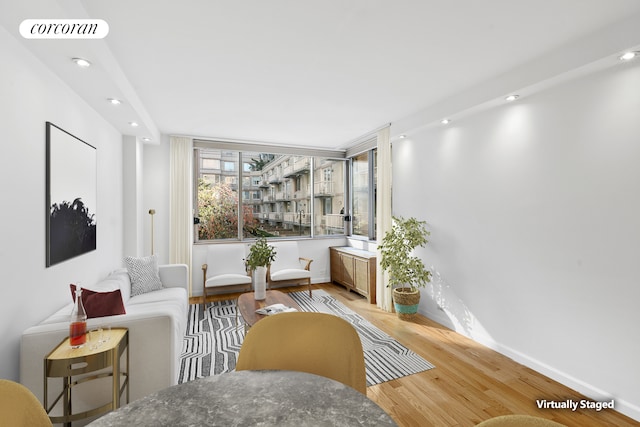 sitting room with baseboards, visible vents, wood finished floors, and recessed lighting