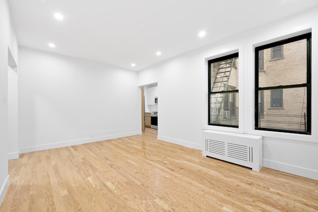 spare room featuring baseboards, light wood-style flooring, and recessed lighting