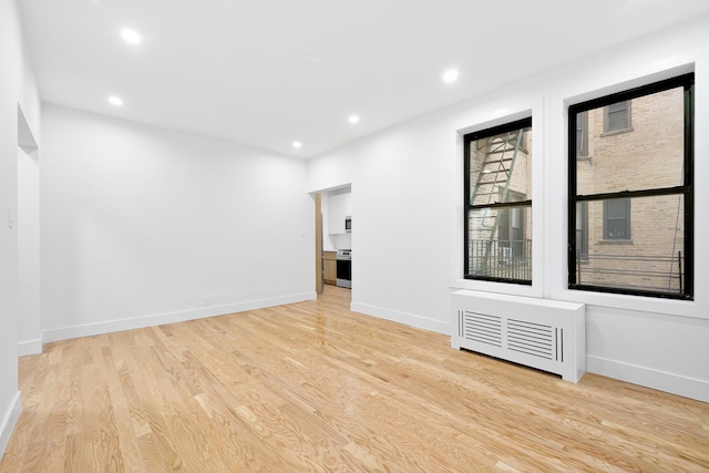 spare room with light wood-type flooring, baseboards, and recessed lighting